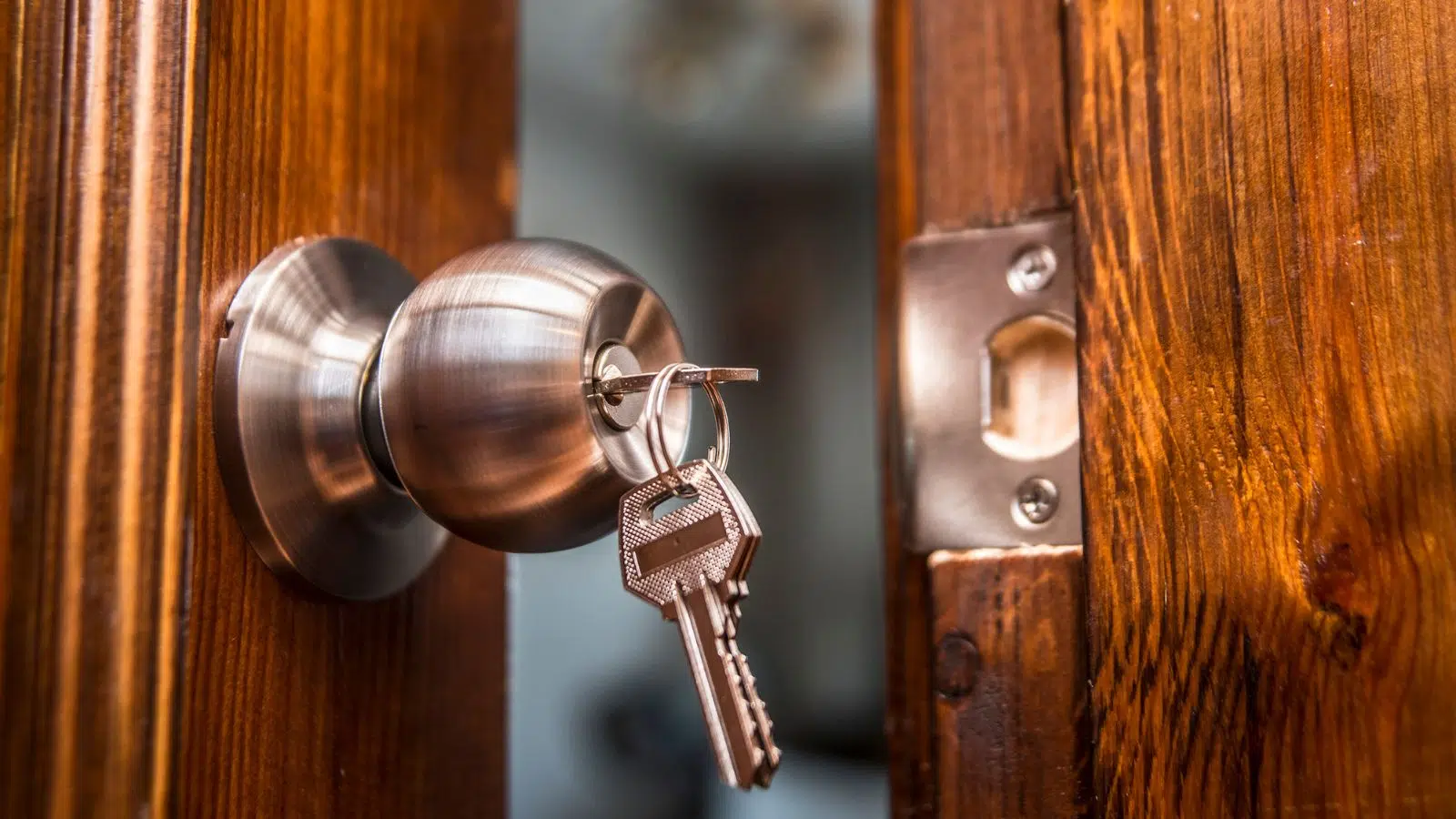 open door, knob and keyhole on wooden door, close up image.