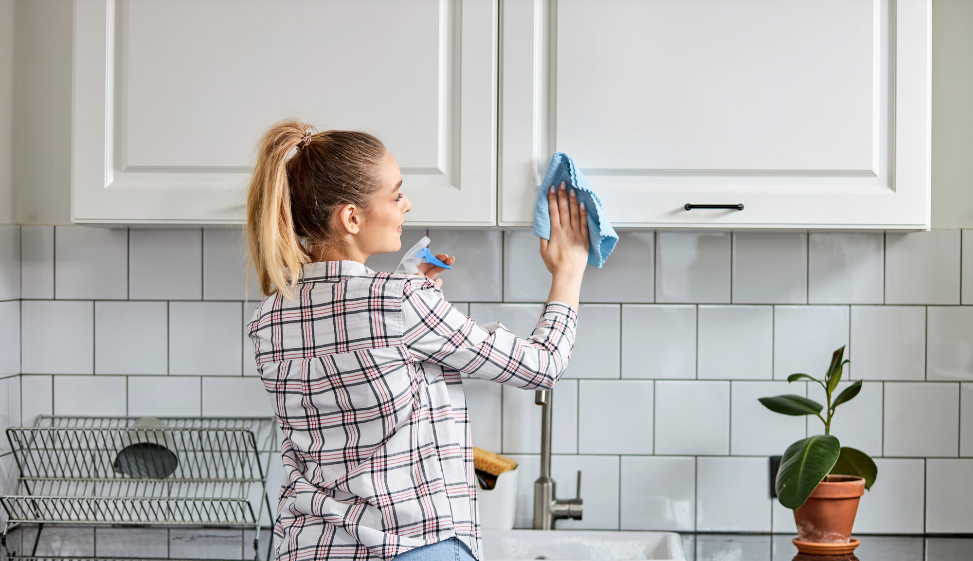 woman cleaning kitchen cabinet